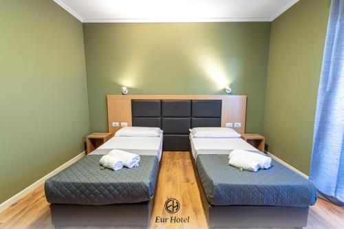 EURHOTEL في فلورنسا: سريرين في غرفة بجدران خضراء