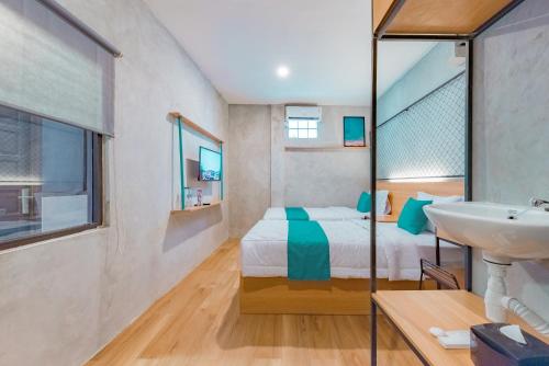 um pequeno quarto com uma cama e um lavatório em Ultima Guest House em Bandung