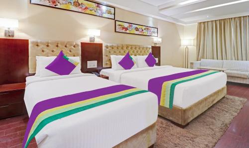 a hotel room with two beds with rainbow sheets at Hotel Park N in Vijayawāda