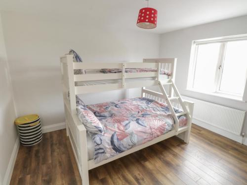 a white bunk bed in a room with wooden floors at Purteen in Achill