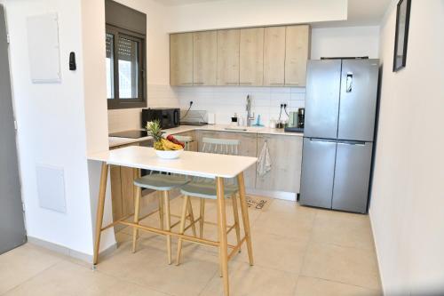 a kitchen with a table and a refrigerator at Casa Cohen C Kineret קאסה כהן סי כנרת in Migdal