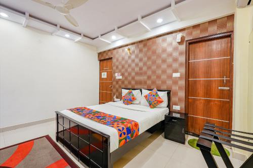 a bedroom with a bed and a wooden door at FabExpress Amazing Inn in Bangalore