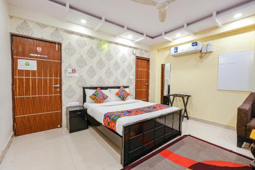 a bedroom with a bed and a door and a chair at FabExpress Amazing Inn in Bangalore