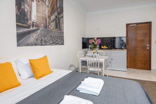 ein Schlafzimmer mit einem Bett mit gelben Kissen und eine Küche in der Unterkunft Palais gare du Nord in Brüssel