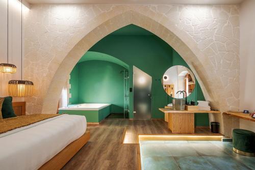 a bedroom with a bed and a bathroom with a tub at Madonna del Mare in Chania