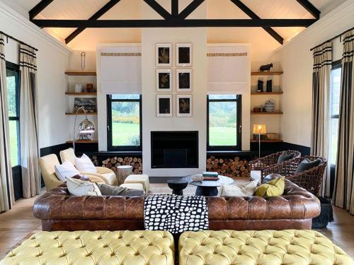 sala de estar con sofá de cuero y TV en Rockwood Karkloof Farm House and Farm Cottage, en Howick