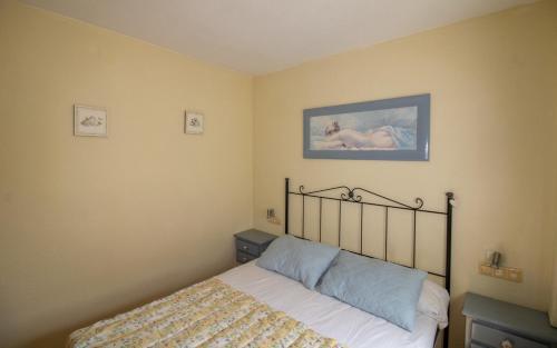 a bedroom with a bed and a painting on the wall at ATICO CON TERRAZA EN EL CENTRO Albert Villas in Alcossebre