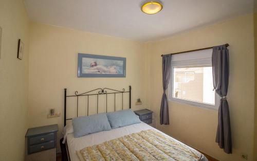 a bedroom with a bed and a window at ATICO CON TERRAZA EN EL CENTRO Albert Villas in Alcossebre