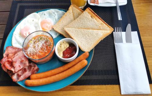 a blue plate of breakfast food with eggs sausage and toast at Willa Pieńkowskich in Gdynia
