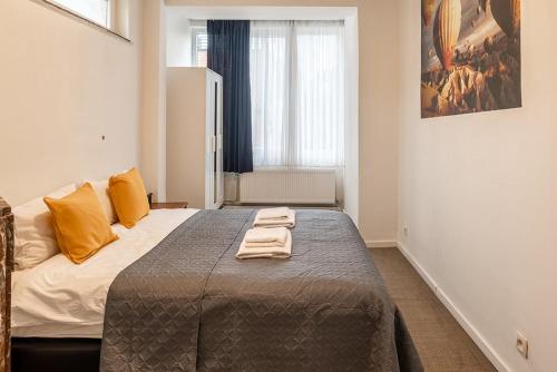ein Schlafzimmer mit einem Bett mit zwei Handtüchern darauf in der Unterkunft Palais gare du Nord in Brüssel