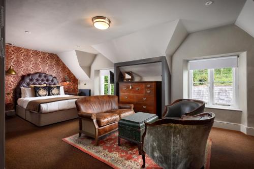 a bedroom with a bed and a desk and a chair at The Bath Hotel in Lynmouth