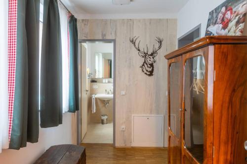 a hallway with a bathroom with a deer head on the wall at Hotel Freischütz in Landshut