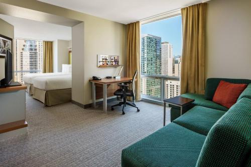 a hotel room with a couch and a bed and a desk at SpringHill Suites Chicago Downtown/River North in Chicago