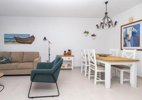 a living room with a couch and a table and chairs at 105 Kings Palace - Fabulous 2 Bed, 2 bath, Large Patio with Garden - Sea Views in Paphos City