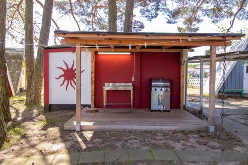 a shed with a stove and a red wall at Ostseecamping Peenemündung in Freest