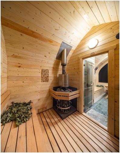 an inside view of a wooden cabin with a stove at Guest house Lilac in apple tree park in Nākotne