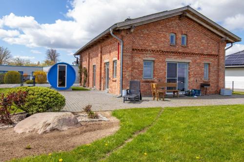 Una casa de ladrillo con un círculo azul alrededor. en Ferienhaus am Hafen, en Stahlbrode