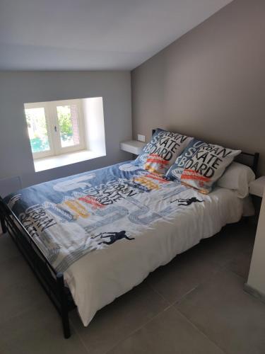 a bed with a comforter and pillows in a bedroom at L oxygène Ardechois gîte 2 in Ruoms