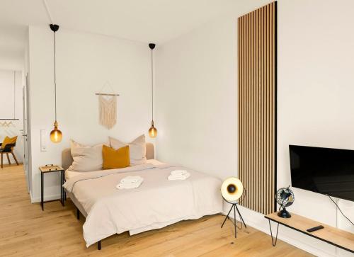 - une chambre avec un grand lit et une télévision dans l'établissement Modernes Apartment im Kaiserkiez, à Oldenbourg