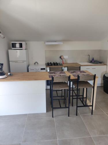 a kitchen with a table and some chairs in it at L oxygène Ardechois gîte 2 in Ruoms