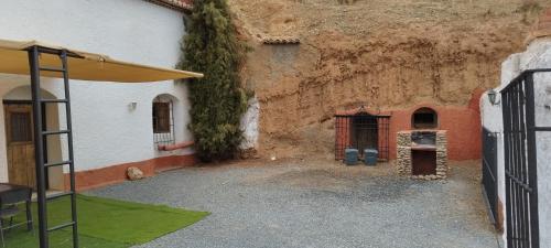 a courtyard of a building next to a wall at Casas Cueva y Cortijo La Tala en Guadix in Guadix