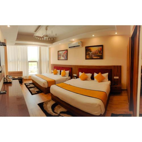 a hotel room with two beds with orange pillows at The Royal Bhumesh in Katra