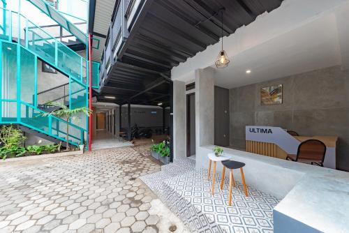 a lobby with a staircase and a table and chairs at Ultima Guest House in Bandung