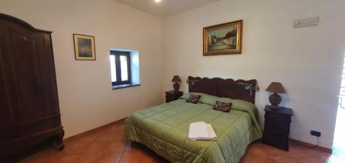 a bedroom with a bed with a green bedspread at La Cicogna in Agerola
