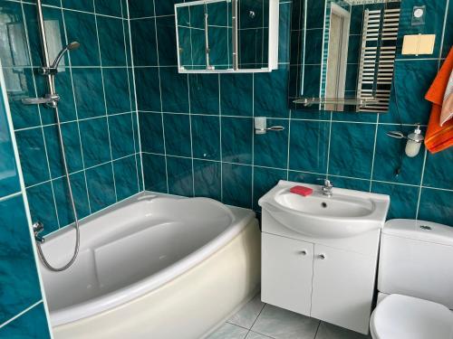 a bathroom with a tub and a sink and a toilet at Mieszkaj U Marty in Jaworzno