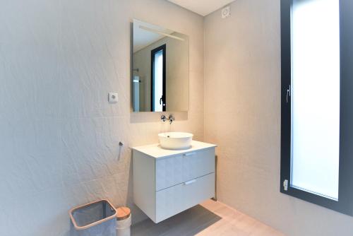 a bathroom with a sink and a mirror at Moradia Sussurros do Mar in Nazaré