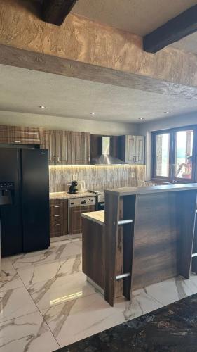 a kitchen with a black refrigerator and a counter at ВАЛ -МАЦА-7- яз Жребчево in Tvŭrditsa