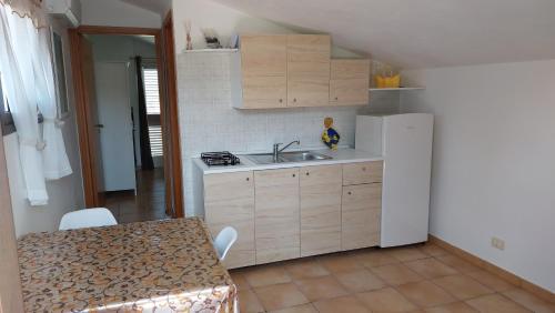 a kitchen with a sink and a table and a refrigerator at Villa Giorgia in Noto Marina