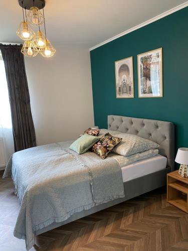 1 dormitorio con 1 cama con pared azul en Lu Residence - Unique Apartments en Oświęcim