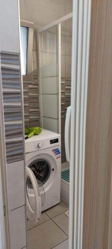a washer and dryer in a small room with a door at Stay With Oleg C17 in Paralimni