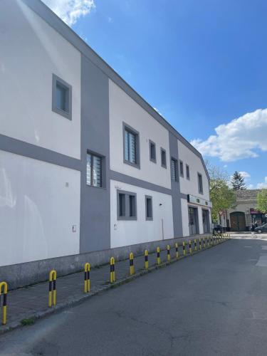 a large white building with yellow barriers in front of it at Morpheus apartmani in Sremska Mitrovica