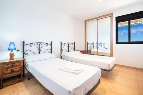 1 dormitorio con 2 camas, escritorio y ventana en Coblanca 8-92 Apartment Levante Beach, en Benidorm