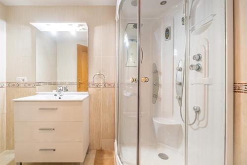 a white bathroom with a shower and a sink at Coblanca 8-92 Apartment Levante Beach in Benidorm