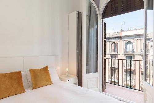 バルセロナにあるスイーツ4デイズ ガウディ アシャンプラのベッドルーム(白いベッド1台、大きな窓付)