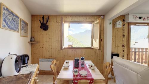 une petite cuisine avec une table et une fenêtre dans l'établissement Grand Cerf 67 appartement Saint Jean D Aulps, à Saint-Jean-dʼAulps