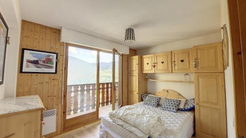 une chambre avec un lit et une grande fenêtre dans l'établissement Grand Cerf 67 appartement Saint Jean D Aulps, à Saint-Jean-dʼAulps