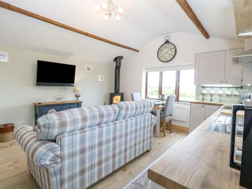 a living room with a couch and a kitchen at The Annexe, Grange Farm in Norwich