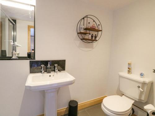 a bathroom with a white toilet and a sink at The Annexe, Grange Farm in Norwich