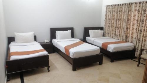 two beds in a room with at Capri Residency in Islamabad