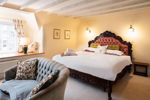 a bedroom with a large bed and a couch at The Craftsman's Cottage in Alnwick