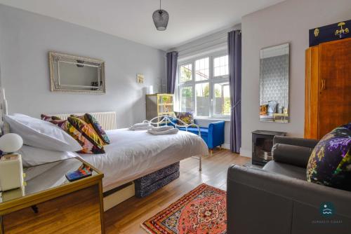 a bedroom with a bed and a couch at Bowleaze Hideaway - beachside dog friendly in Weymouth