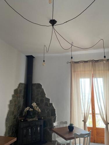 a living room with a table and a stone fireplace at Domus Petra in Rocca Cilento