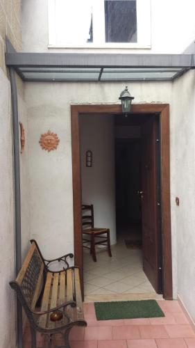 a porch with a bench and a open door at B&B Sogni Goti in SantʼAgata deʼ Goti