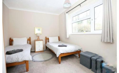 a bedroom with two twin beds and a window at Exclusive 2 bedroom bungalow Oulten Broad in Carlton Colville
