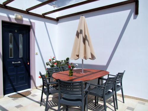 a patio with a table and chairs with an umbrella at Villa Aliki in Myrtos