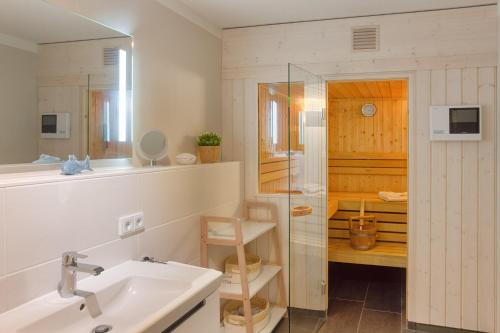 a bathroom with a sink and a shower and a mirror at Yachtenkieker in Heiligenhafen